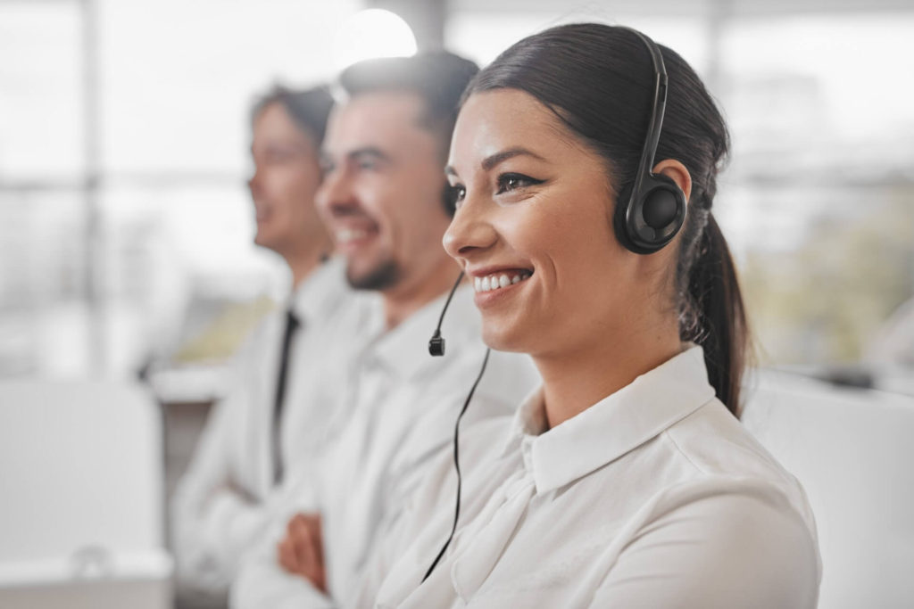 Cheerful call center worker near colleagues